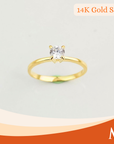 A yellow gold solitaire ring with a round-cut clear gemstone in a four-prong setting