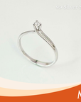 A silver solitaire engagement ring with a round-cut clear gemstone