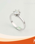 A silver solitaire engagement ring with a round-cut clear gemstone in a six-prong setting